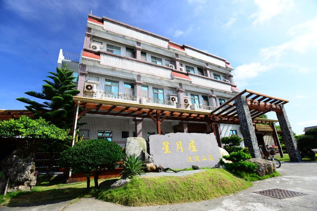 un bâtiment avec un panneau devant lui dans l'établissement Star-Moon B&B Green Island, à Green Island