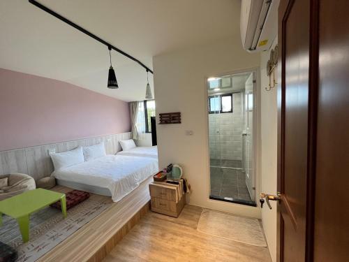 - une petite chambre avec un lit et une table verte dans l'établissement Yu Shou Hao Hsien Guesthouse, à Fushi