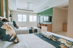 Cette chambre comprend deux lits et une télévision. dans l'établissement Diane Residences, à Mabolo