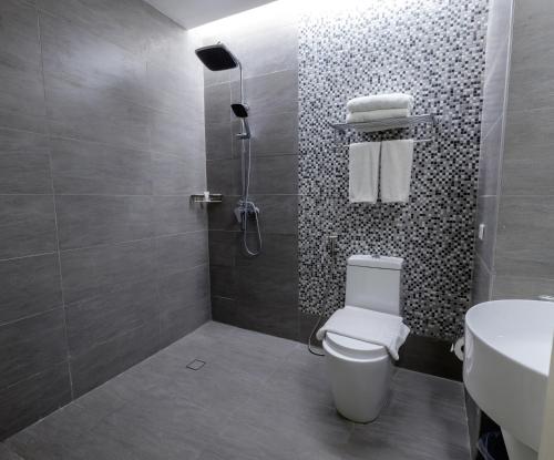 La salle de bains est pourvue d'une douche, de toilettes et d'un lavabo. dans l'établissement One Central Hotel & Suites, à Cebu